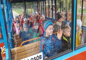 dzieci machają przez szybę pociągu