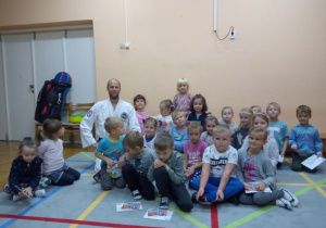 dzieci pozują do zdjęcia z instruktorem taekwon-do