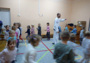 instruktor stoi w środku koła a dzieci biegną po kole