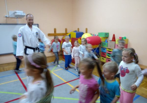 instruktor stoi w środku koła a dzieci biegną po kole
