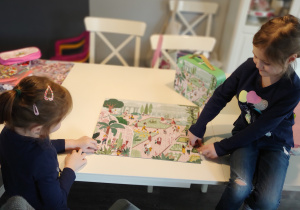 dziewczynki układają puzzle na stole