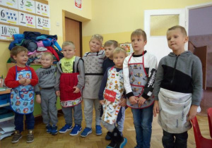chłopcy stoją w fartuszkach