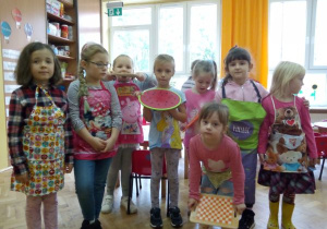 dziewczynki w fartuszkach trzymają deski do krojenia