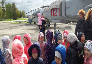 dzieci stoją przed samolotem a tata lotnik trzyma na rękach swoją córkę