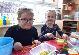 dziewczynki kroją plastikowymi, białymi nożami
