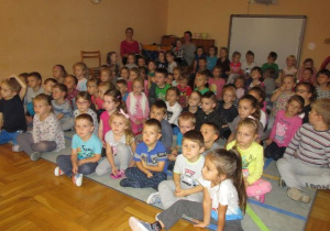 dzieci siedzą na dywanie