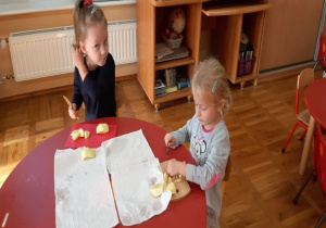 dziewczynki kroją jabłka na drewnianych deskach