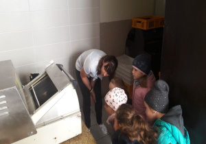 pani i dzieci schylają się przy maszynie do chleba