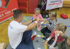 bandażowanie ręki dziewczynki przez instruktora