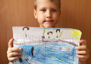 chłopiec trzyma swoja pracę: ludzie grają w siatkę w wodzie