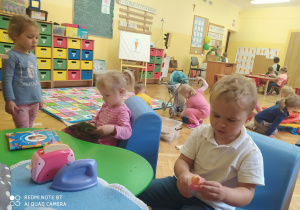maluszki bawią się w różnych miejscach sali, przy stoliku i na podłodze