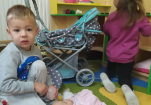 chłopiec z dziewczynką bawia się kąciku dom wózkiem i lalką
