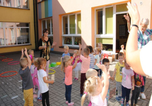maluszki klaszczą w dłonie stojąc w kole na tarasie