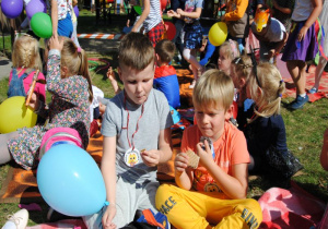 chłopcy piknikują na kocu