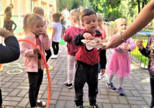 maluszki częstują się ciasteczkami na tarasie