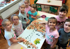 dziewczynki z gr. V przy stoliku wykonują pracę plastyczną: drzewo jarzębiny