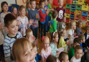 dzieci stoją i klaszczą i uśmiechają się