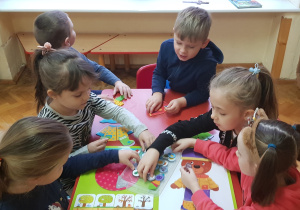 dziewczynki umieszczają symbole pogody na kalendarzu pogody
