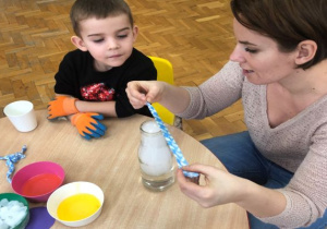 pani demonstruje chłopcu doświadczenie przy stoliku