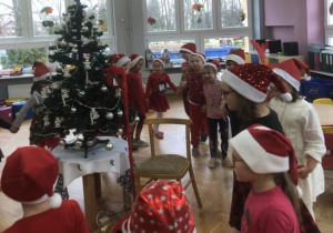 dzieci tańczą wokół choinki