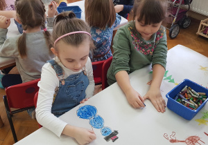 dziewczynki na obrusie rysują bałwana