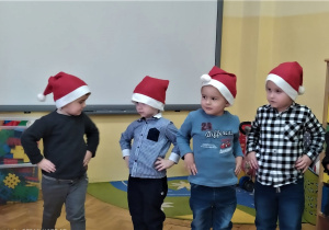 chłopcy w czerwonych czapkach stoją i trzymają ręce na biodrach