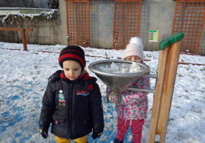 dzieci wsypały do dużego lejka śnieg