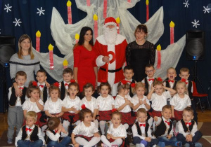 zdjęcie grupowe dzieci z gr1 w strojach w białych i czerwona kratkę z nauczycielkami