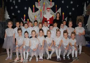zdjęcie grupowe dzieci z gr3 w strojach srebrno - biało - szarych z Mikołajem i nauczycielką