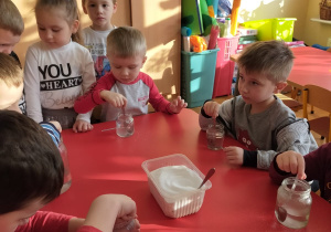 dzieci mieszają sól w słoikach