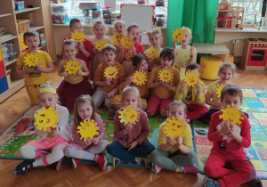 dzieci z grupy VI pokazują wykonane słoneczka na talerzach papierowych