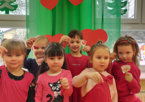 dziewczynki z upominkami - czerwone serduszka na sznurku i lizaki w kształcie serduszek