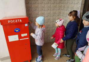 dziewczynka wrzuca kartkę do skrzynki a kolejne dzieci czekają na swoją kolejkę