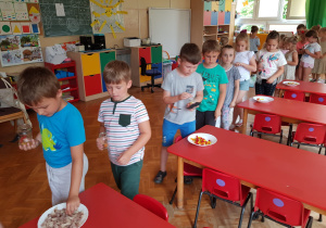dzieci komponują słoiczek słodkości dla taty - wrzucają słodkości do słoiczka