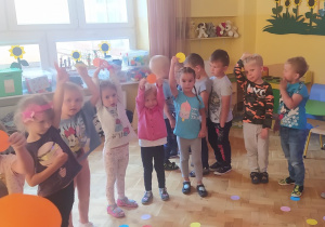dzieci w kole trzymają kolorowe kropki