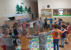 dzieci stoją w kole trzymając się za ramiona