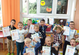 chłopcy z grupy IV z dyplomami i autkami zawieszonymi na kolorowych tasiemkach na szyi