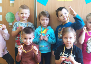 dzieci z grupy VIII pozują do zdjęcia w koralach z makaronu