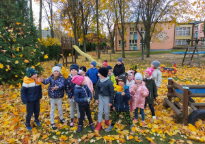 na dzieci w ogrodzie przedszkolnym lecą kolorowe liście