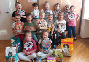 dzieci z grupy V z zebraną karmą dla zwierząt i maskami piesków