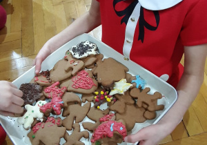 dziewczynka częstuje ciasteczkami ułożonymi na tacy