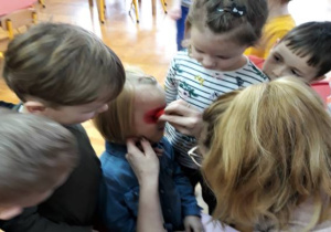 mama maluje maskę biedronki dziewczynce