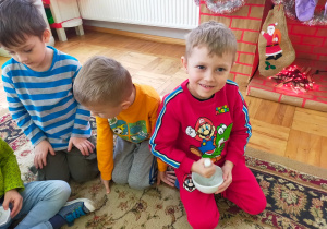 chłopiec uciera ceramiczną pałką w miseczce