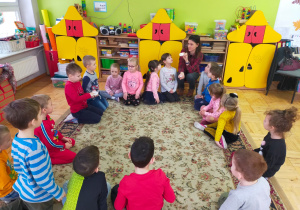 dzieci siedzą w kole i słuchają mamy