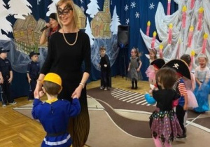 nauczycielka w czarnej, ażurowej masce na oczach tańczy z budowniczym