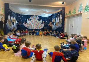 dzieci siedzą w dużym kole na podłodze