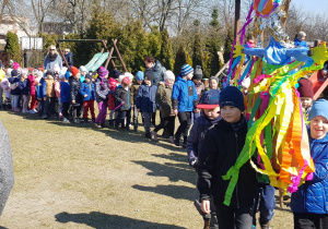 korowód przedszkolaków z Marzanną maszeruje po ogrodzie