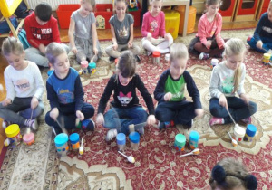 dzieci grają na bębenkach z puszek pałeczkami z korków i patyczków do szaszłyków
