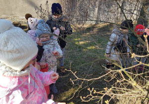 dzieci oglądają krzak z pąkami liści bzu