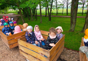 dzieci jadą w wagonikach w kształcie skrzynek drewnianych na owoce